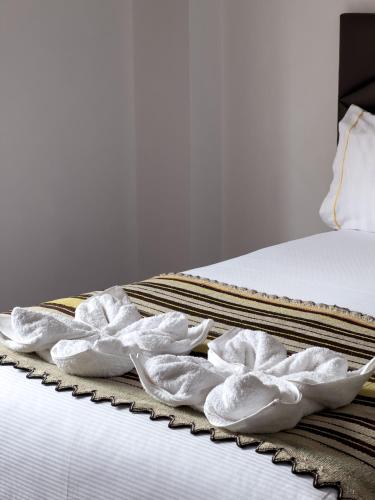 two white crumpled towels sitting on a bed at Hotel Andes de Urubamba in Urubamba