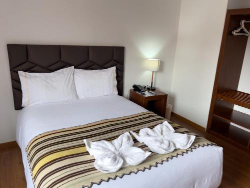 a hotel room with a bed with towels on it at Hotel Andes de Urubamba in Urubamba
