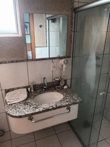 a bathroom with a sink and a shower at Suíte Grand Hotel Dolphin in Caldas Novas