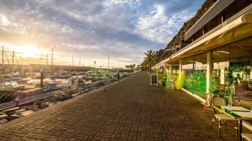 a sidewalk next to a marina with tables and chairs at Madeira Inn Vilamar in Calheta