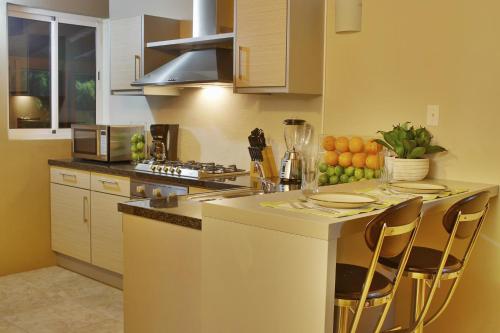 a kitchen with a counter with chairs and a table at Costa Esmeralda Village in Palm-Eagle Beach