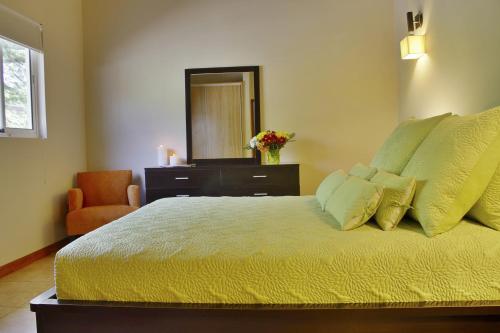 a bedroom with a bed with a dresser and a mirror at Costa Esmeralda Village in Palm-Eagle Beach