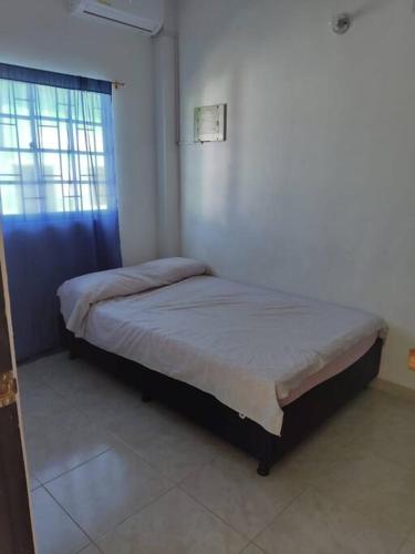 1 Schlafzimmer mit 2 Betten in einem Zimmer mit Fenster in der Unterkunft Apartamento Arboletes a 2 cuadras playa principal in Arboletes