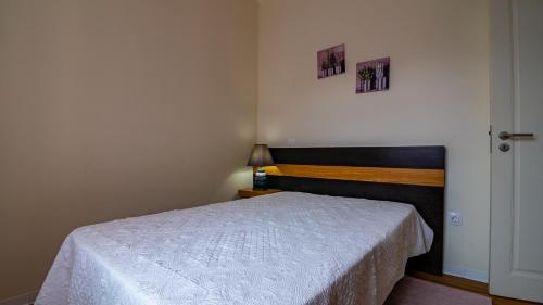a small bedroom with a bed and a lamp at Madeira Inn Vilamar in Calheta
