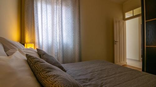 a bedroom with a bed with pillows and a window at Madeira Inn Vilamar in Calheta