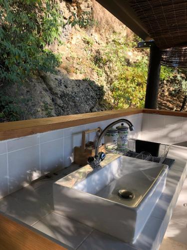 d'un évier dans une cuisine avec une fenêtre. dans l'établissement L'Olivier Fleurie Barjols, à Barjols