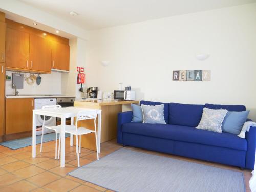 ラゴスにあるSea View Apartment Near Meia Praia Beach in Lagos!の青いソファとキッチンのあるリビングルーム