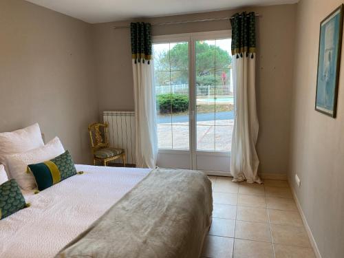 帕米耶的住宿－Gîte du Mercadal Les Pujols，一间卧室设有一张床和一个大窗户
