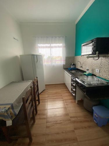 a kitchen with a sink and a refrigerator in a room at Pousada Viva a Vida in Ilha Comprida