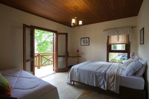 1 dormitorio con cama y ventana en Bela vista - Secretário en Petrópolis