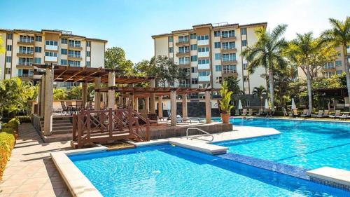 a swimming pool in front of a building at Family condo, pool, beach and surf in Jacó