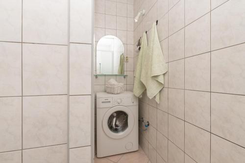 a laundry room with a washing machine and a mirror at Apartments Talija in Drasnice