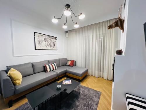 salon z kanapą i stołem w obiekcie Redstripes Apartment w Salonikach