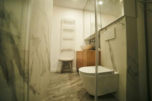 a bathroom with a toilet and a glass shower at Ultracentral two rooms apartment in Bucharest in Bucharest