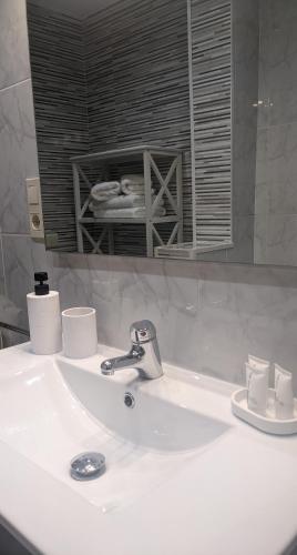 a bathroom sink with a faucet and a mirror at Arran de Mar Cambrils in Cambrils