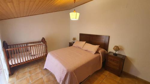 a small bedroom with a bed and a crib at Río Hereza in Arroyo Frio