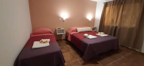 um quarto de hotel com duas camas com toalhas em Apart HAMU em El Calafate