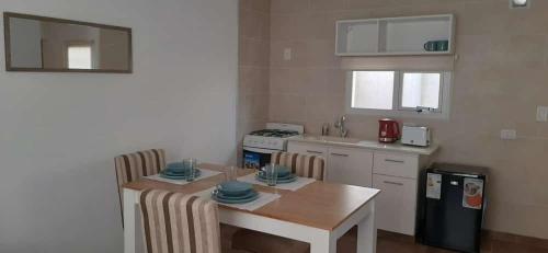 eine kleine Küche mit einem Tisch und einer Arbeitsplatte in der Unterkunft Apart HAMU in El Calafate