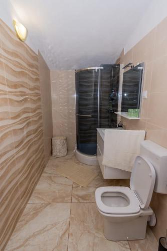 a bathroom with a toilet and a sink and a window at Villa Dreamer in Rogoznica