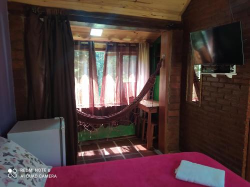 a room with a bed and a hammock in a room at Pousada Donna Rose in Penedo