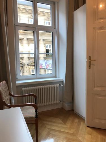 Habitación con ventana, silla y radiador en Luxury Apartment Neubaugasse, en Viena