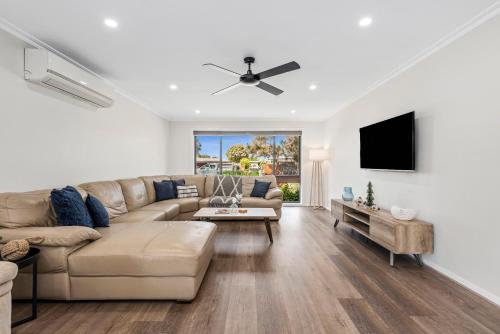 a living room with a couch and a flat screen tv at Tidal Waves on Lowe - Ocean Grove in Ocean Grove