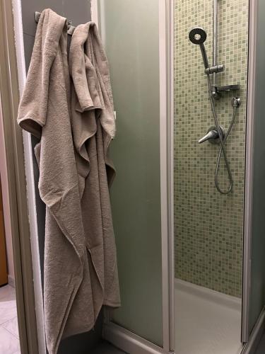 a bathroom with a shower with a towel on the door at Luminoso Monolocale zona servita in Legnano