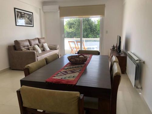 sala de estar con mesa de madera y sofá en Hermoso departamento céntrico con cochera en Tandil