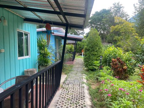 a walkway next to a house with a blue building at ทับศิลารีสอร์ท Tubsila Resort in Chongsadao
