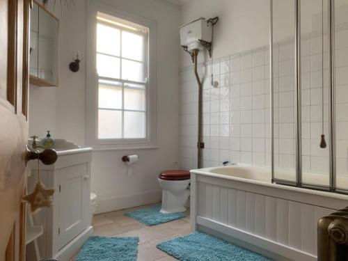 ein Bad mit einer Badewanne, einem WC und einem Fenster in der Unterkunft CB53 Tower Bridge Townhouse 2 bathrooms & Free parking in London