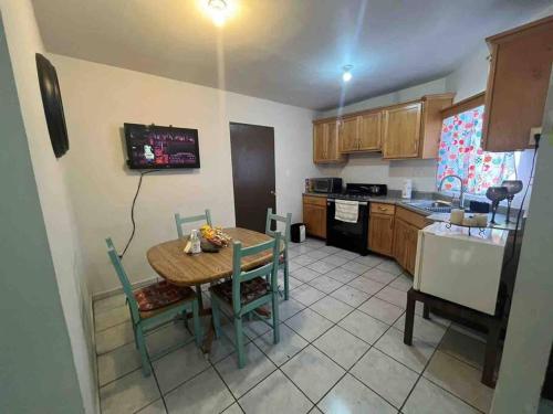 een keuken met een tafel en stoelen en een keuken met een koelkast bij Casa Joyas in San Luis Río Colorado