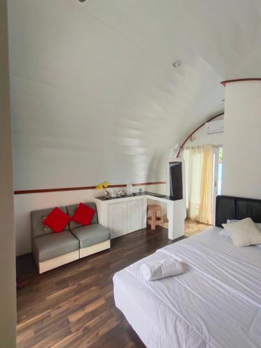 1 dormitorio con cama, sofá y TV en Mercy Cottage en Langgur