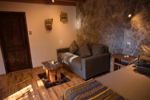 a living room with a couch and a table at Lodge Quelana in San Pedro de Atacama