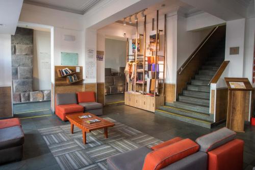 a lobby with couches and a table and stairs at Casa Andina Standard Cusco Catedral in Cusco