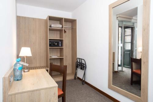 a mirror in a room with a desk and a chair at Casa Andina Standard Cusco Catedral in Cusco