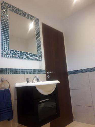 y baño con lavabo y espejo. en OLIVIAS LOFTS en Ushuaia