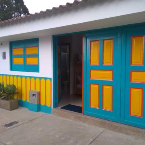 una casa de juguetes con puertas azules y naranjas en La casa de Alejo, en Salento