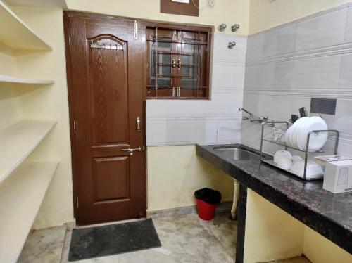 a bathroom with a wooden door and a sink at Home to explore Food, History & Shopping in Hyderabad