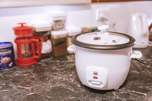 a white slow cooker sitting on a kitchen counter at Comfortable Cosy Retreat in Rotorua