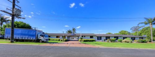 un camión azul estacionado frente a una casa en James Street Motor Inn, en Toowoomba