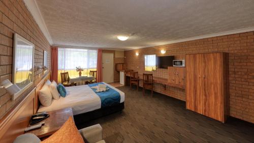 a hotel room with a large bed and a kitchen at James Street Motor Inn in Toowoomba