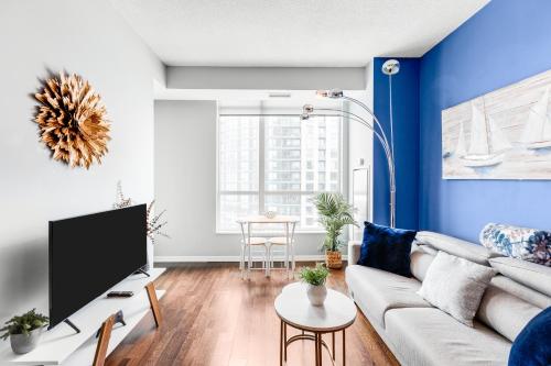 a living room with a couch and a tv at AOC Suites - High-Rise Condo - City View in Toronto