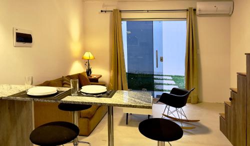 a living room with a kitchen with a table and chairs at Tiny Houses en Asunción. Zona Aeropuerto-Rakiura in Zarate Isla