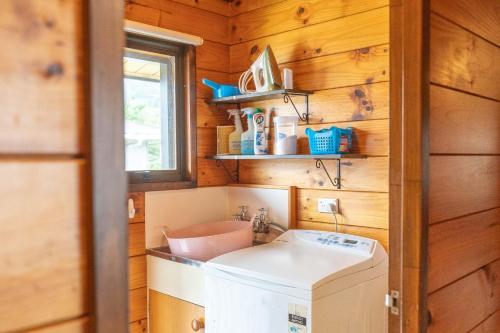 a kitchen with a washer and dryer in a tiny house at Comfortable Cosy Retreat in Rotorua
