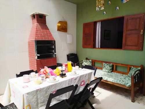 a dining room with a table and a brick oven at Casa Próximo ao Centro in Paraty