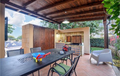 Un patio con mesa y sillas y una cocina. en Nice Home In Marina Di Modica With Wifi, en Marina di Modica