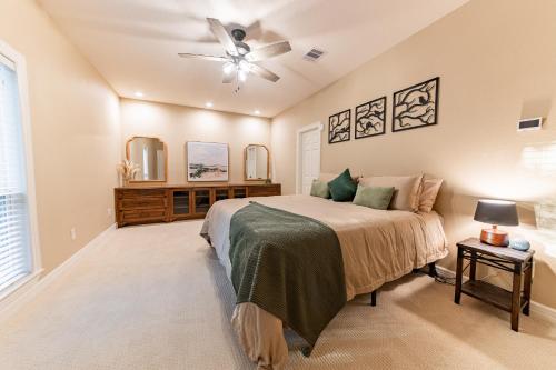 Un dormitorio con una cama y un ventilador de techo. en 2 King Suites with Private Pool and Spa, Texas-Sized Covered Patio and Outdoor Kitchen and BBQ, en Tomball
