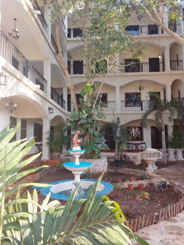 a courtyard with a fountain in front of a building at Hotel Nojoch che in Cobá