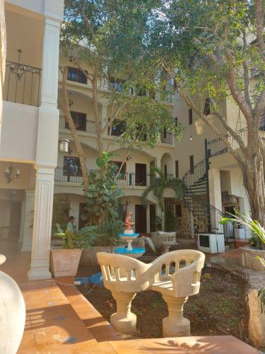 a building with a bench in the middle of a courtyard at Hotel Nojoch che in Cobá