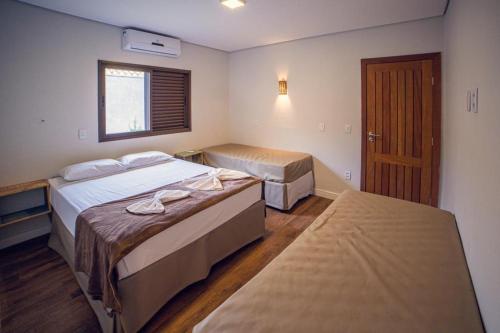 a hotel room with two beds and a window at Suítes Novas no Coração de Bonito in Bonito